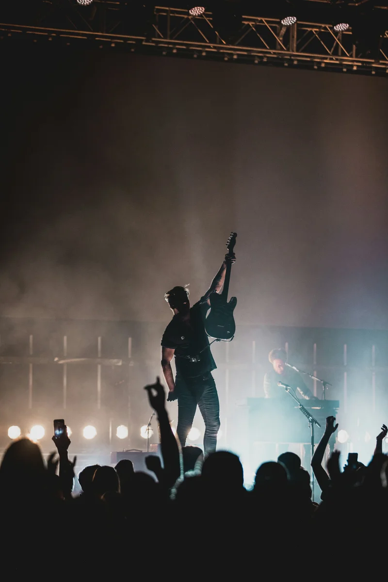 Gitarrist reckt die Gitarre über das Publikum
