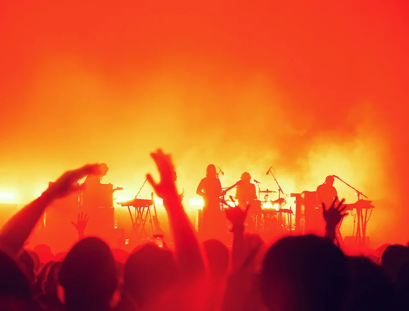 Band auf der Bühne in orangem Gegenlicht und Nebel