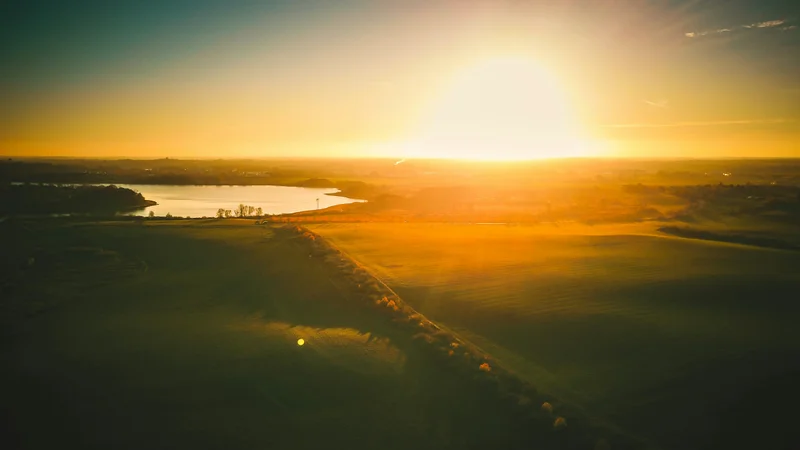 Landschaft mit See bei Sonnenuntergang aus der Luft